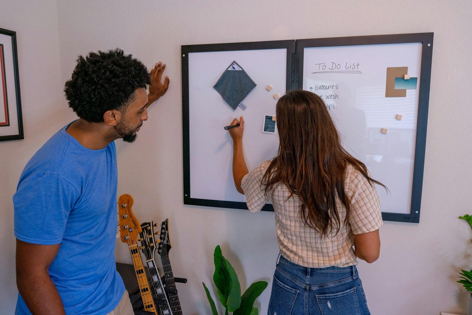Two people sketching a product idea together on a whiteboard.